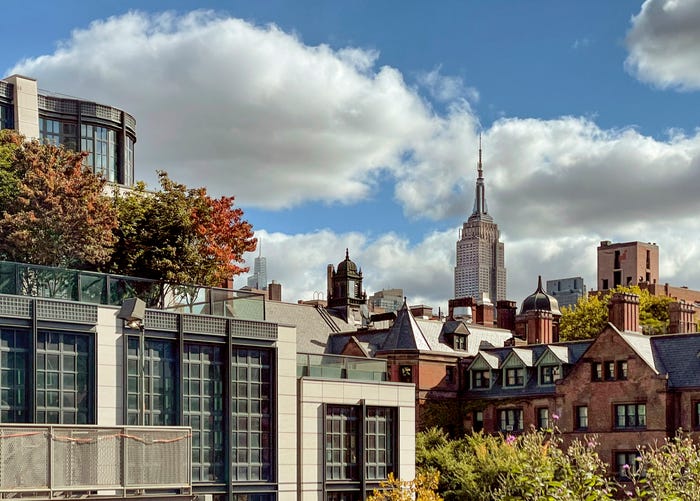 NYC skyline hiding behind a few residential buildings.