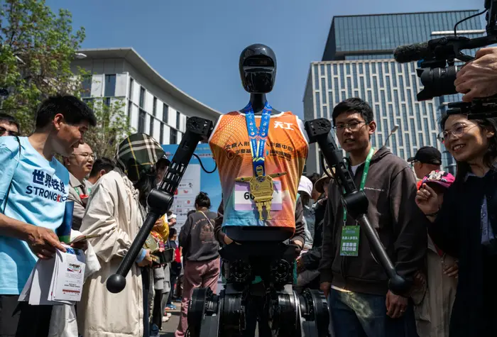 Humanoid robots tripped and fell and took down a handler during a half-marathon in Beijing