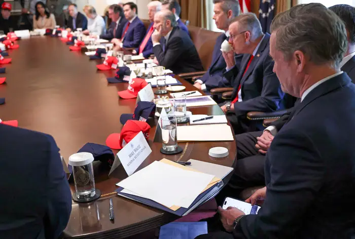Photo appears to show now-former national security advisor Mike Waltz checking Signal during a Cabinet meeting